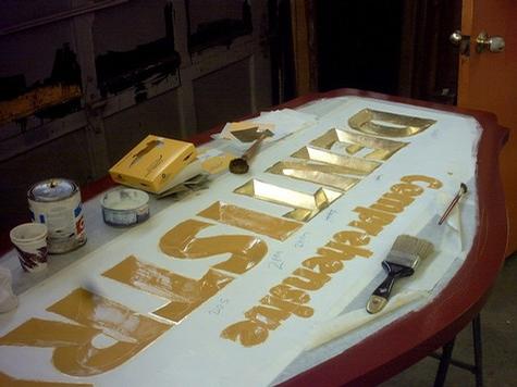 Applying the Gold Leaf to Carved Sign